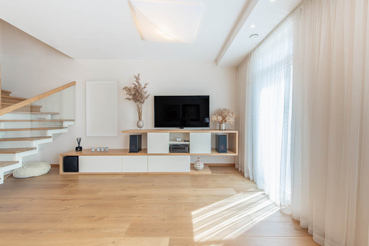 Modern Home Living Room Interior. Luxurious Stylish Modern Apartment. Scandinavian Design. TV Screen, Sunlight, Windows and Curtains. Wide Angle